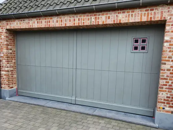 Geschilderde garagepoort in een bakstenen gevel