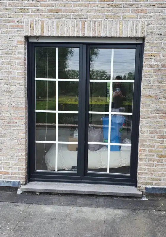 Zwart raamkader in een lichte bakstenen gevel