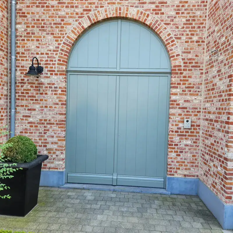 Gelakte dubbele boogpoort in een bakstenen gevel