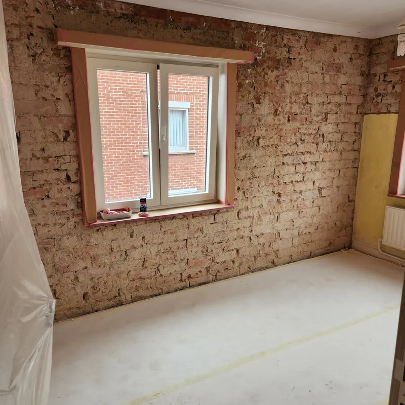 Muur gestript tot op de baksteen, klaar voor herstelling