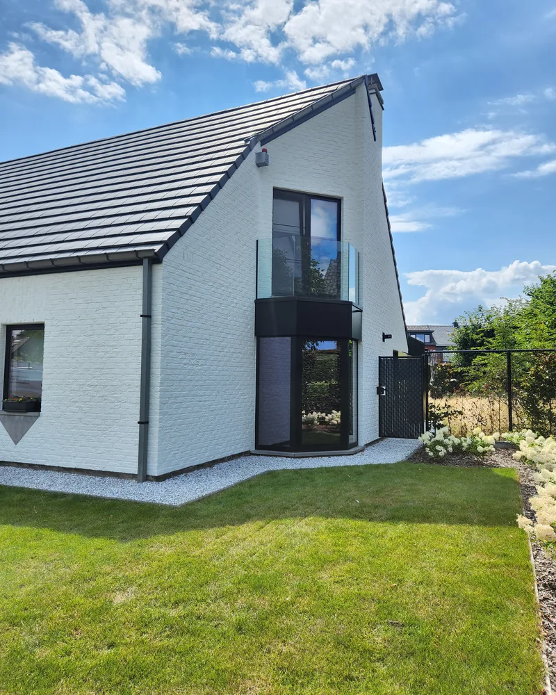 Witte woning met pas geschilderde gevel en zwart buitenschrijnwerk