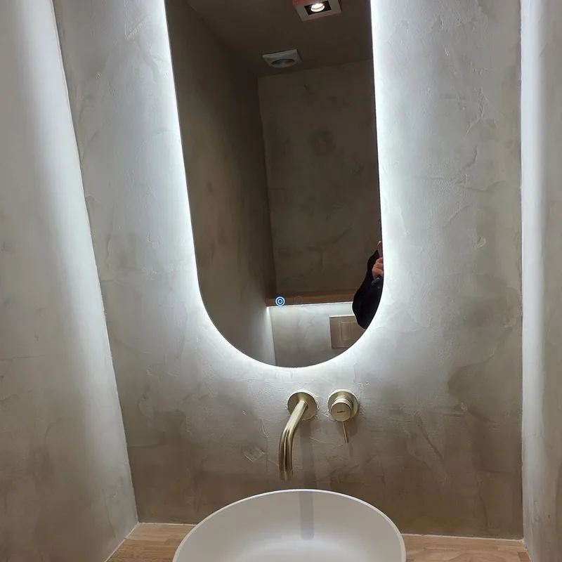 Toilet met ovale spiegel en wanden in decoratieve afwerking