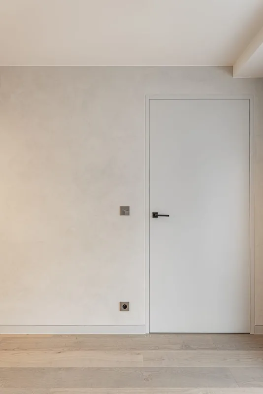 Witte binnendeur en plinten in een lichte kamer