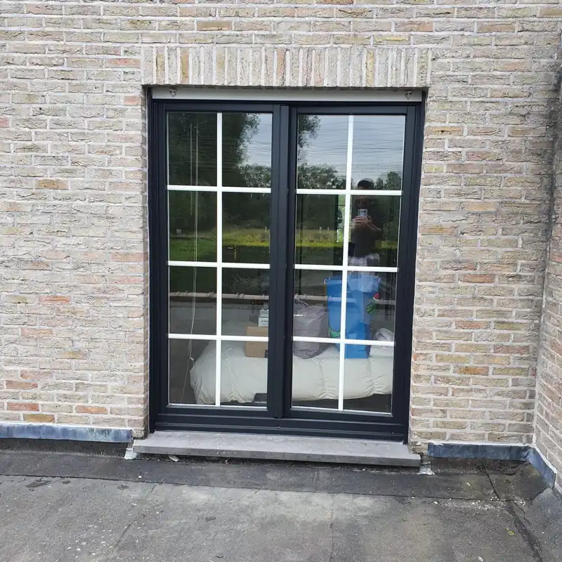 Zwart raamkader in een lichte bakstenen gevel