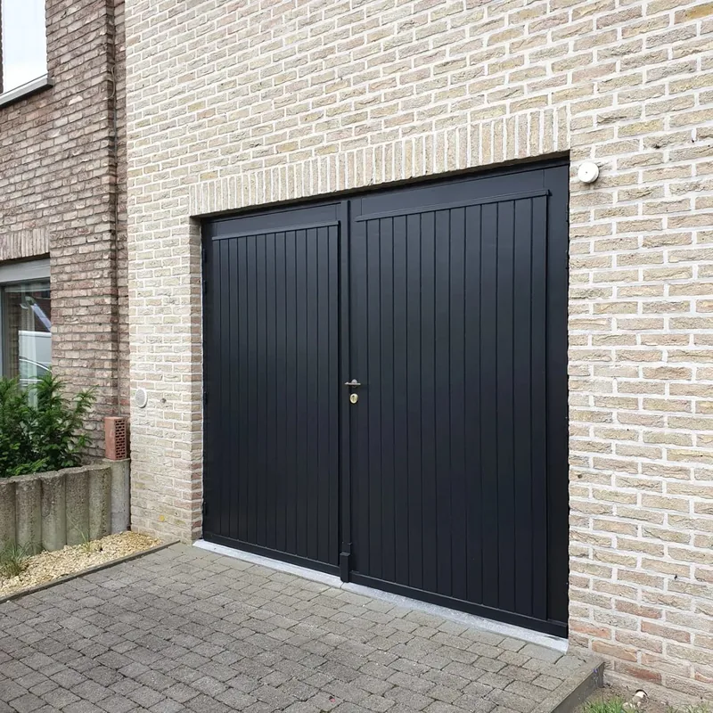 Zwarte garagepoort in een bakstenen gevel