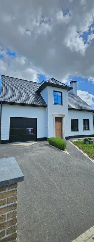 Witte woning met donkere garagepoort