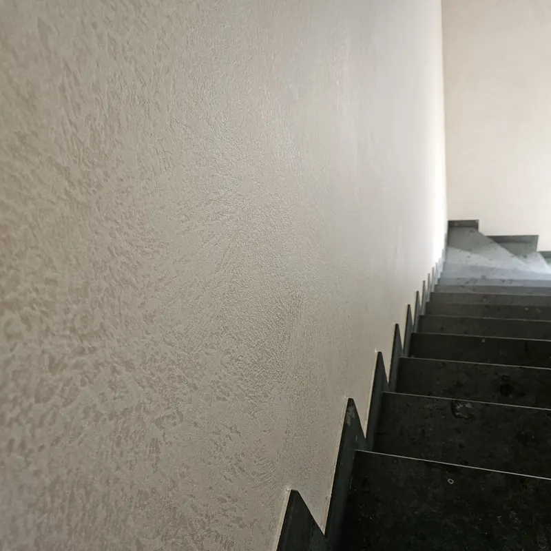 Traphal met een wand in decoratieve structuurafwerking