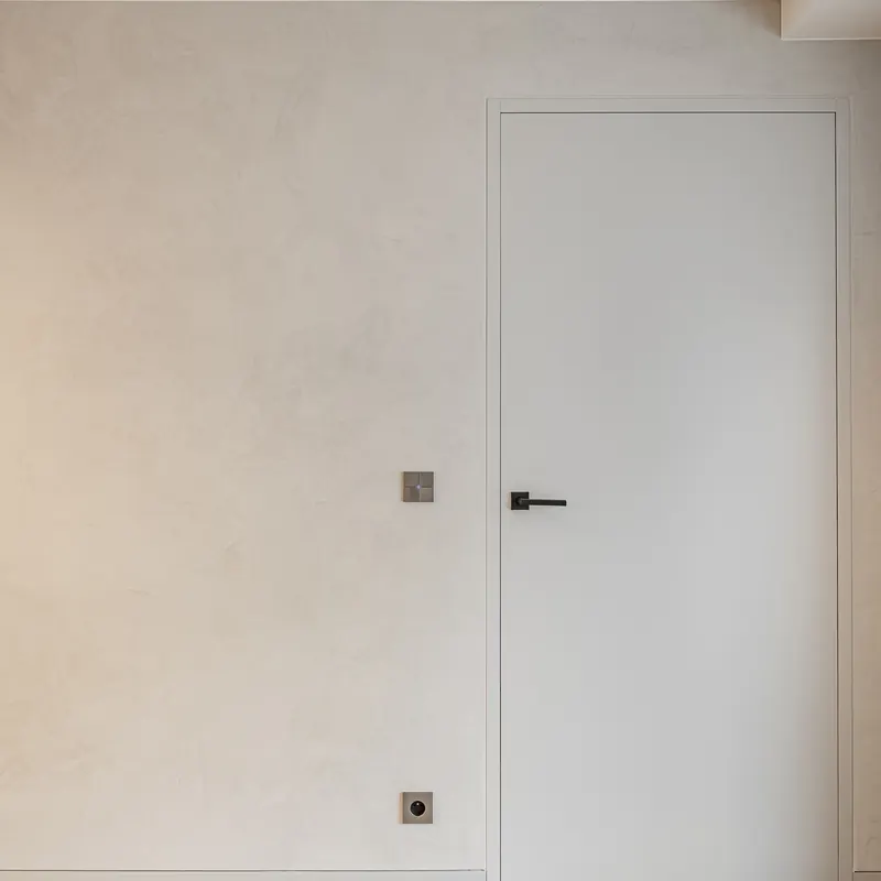 Wand in decoratieve afwerking naast een witte binnendeur