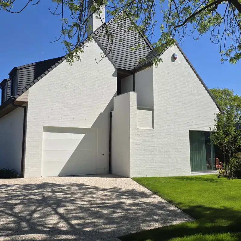 Witte woning met geschilderde gevel en oprit